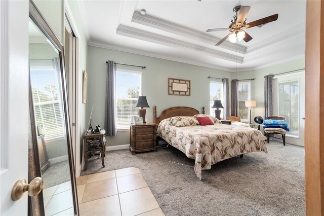 bedroom featuring ceiling fan, a raised ceiling, light tile patterned floors, and crown molding