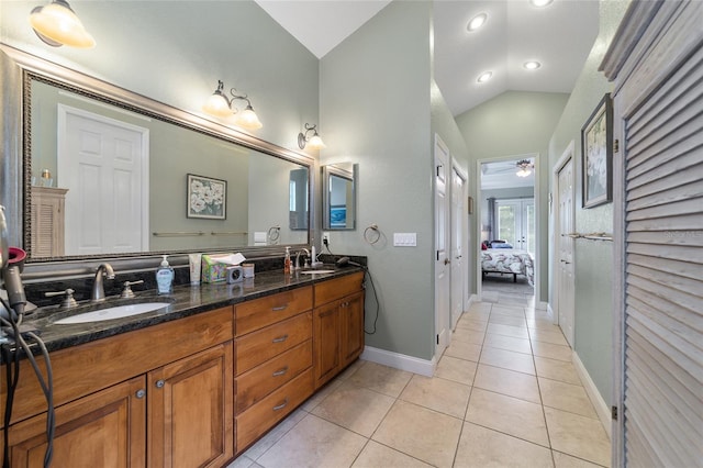 bathroom with ceiling fan, vaulted ceiling, tile patterned flooring, and vanity