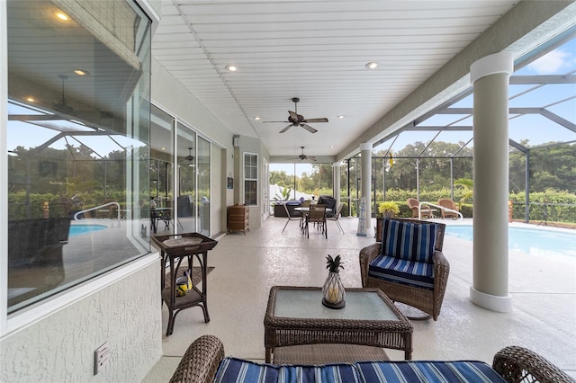 view of patio with ceiling fan, an outdoor living space, and a lanai