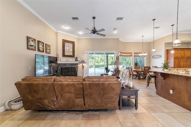 tiled living room featuring ceiling fan with notable chandelier, a high end fireplace, and ornamental molding