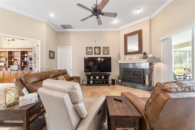 tiled living room with ceiling fan, a high end fireplace, and crown molding