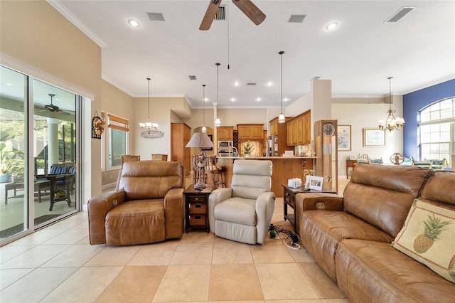 tiled living room with ceiling fan with notable chandelier and ornamental molding