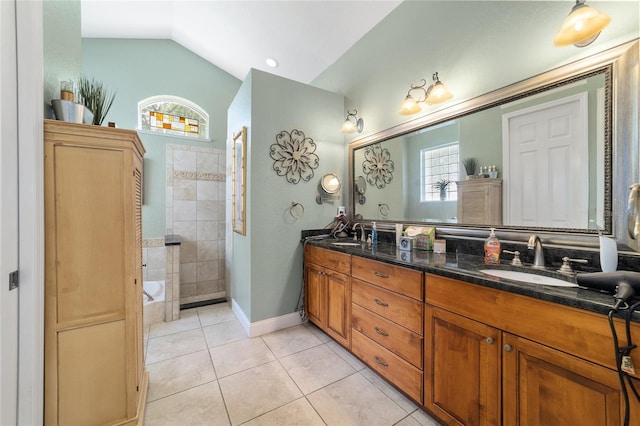 bathroom with tile patterned floors, vaulted ceiling, vanity, and a tub to relax in