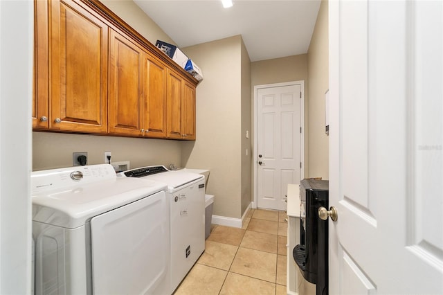 laundry room featuring cabinets, independent washer and dryer, and light tile patterned floors