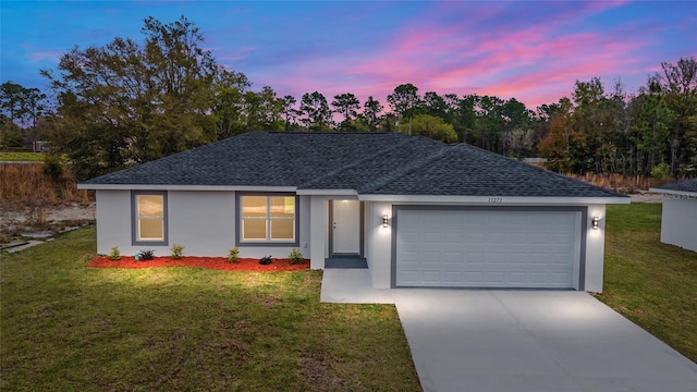 single story home featuring a garage and a lawn