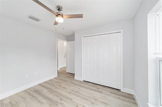 unfurnished bedroom featuring light hardwood / wood-style flooring, ceiling fan, and a closet