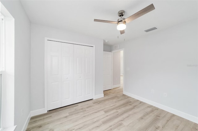 unfurnished bedroom with light hardwood / wood-style floors, ceiling fan, and a closet