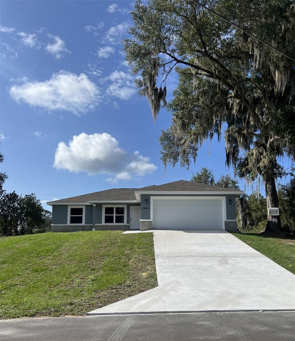 ranch-style home featuring a garage and a front lawn