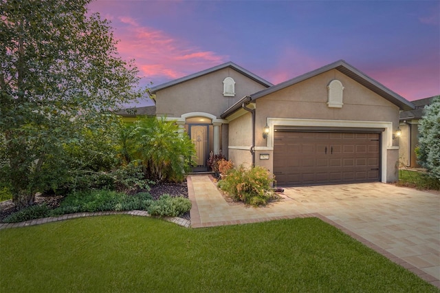 view of front of house with a yard and a garage