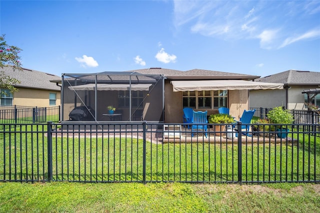 rear view of property with a yard, a patio area, and a lanai