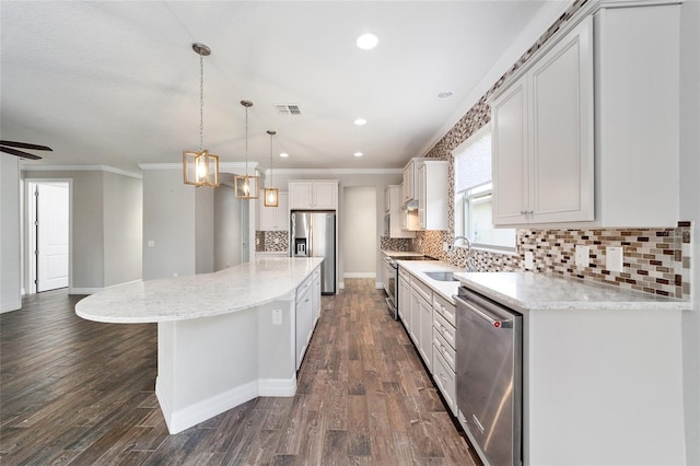 kitchen featuring dark wood-type flooring, a center island, hanging light fixtures, and appliances with stainless steel finishes