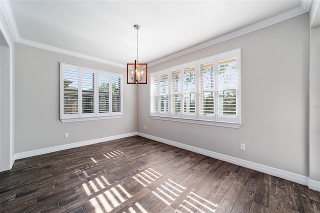 empty room with crown molding, dark hardwood / wood-style floors, and a notable chandelier