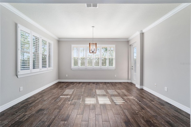 unfurnished dining area with a textured ceiling, dark hardwood / wood-style floors, an inviting chandelier, and crown molding