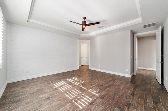 unfurnished room with dark hardwood / wood-style floors, ceiling fan, ornamental molding, and a tray ceiling