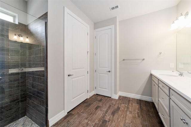 bathroom with hardwood / wood-style flooring, vanity, and an enclosed shower