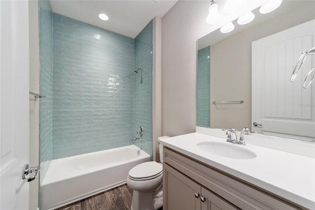 full bathroom with vanity, wood-type flooring, tiled shower / bath combo, and toilet