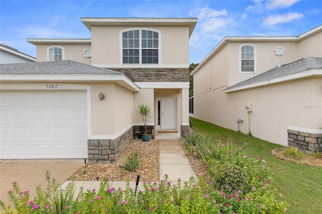 view of property featuring a garage and a front lawn