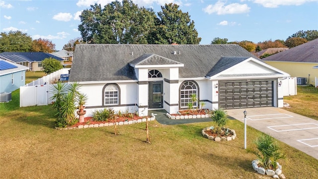 view of front of property with a garage, a front lawn, and central air condition unit