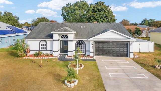 view of front of property with a garage, a front lawn, and solar panels