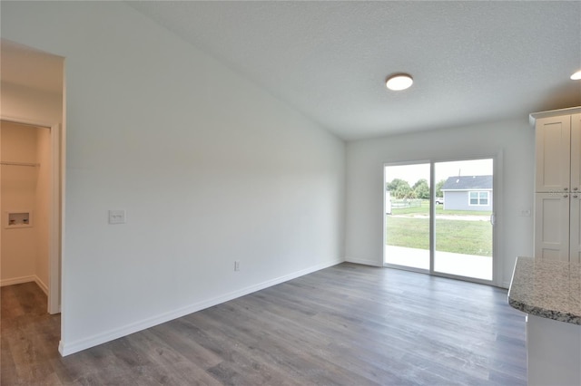 unfurnished living room with a textured ceiling and dark wood-type flooring