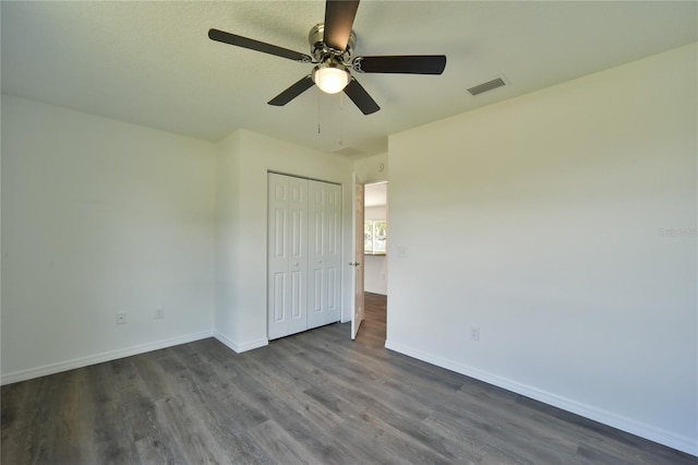 unfurnished bedroom featuring a closet, ceiling fan, and dark hardwood / wood-style flooring