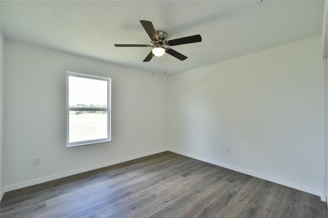 empty room with ceiling fan and dark hardwood / wood-style floors