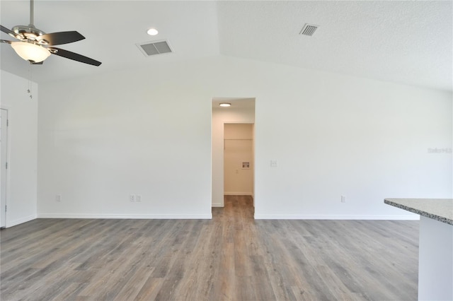 empty room featuring vaulted ceiling, hardwood / wood-style flooring, and ceiling fan