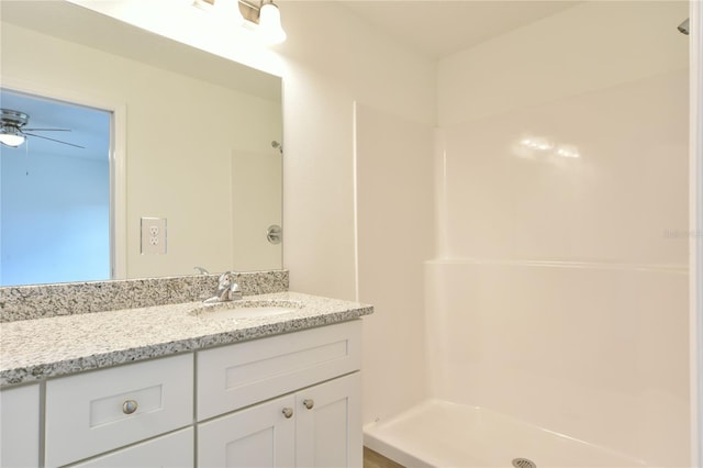 bathroom featuring vanity, walk in shower, and ceiling fan