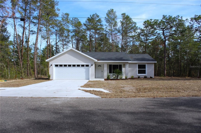 ranch-style house featuring concrete driveway, an attached garage, and a front yard