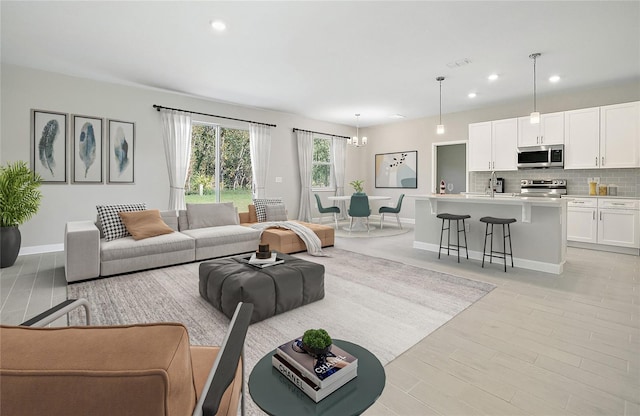 living area featuring light wood-type flooring, visible vents, baseboards, and recessed lighting