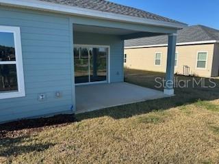 back of property featuring a patio and a lawn