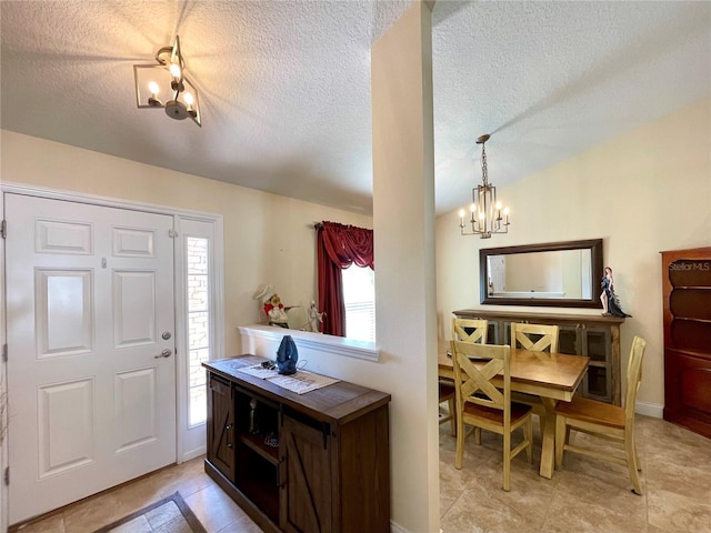 entryway featuring a textured ceiling, plenty of natural light, and a notable chandelier