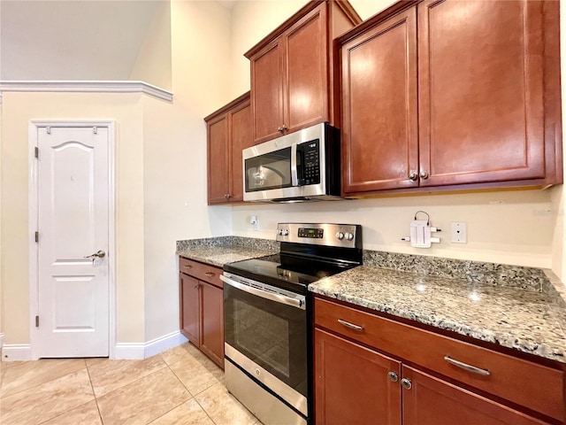 kitchen featuring light stone counters, light tile patterned floors, and appliances with stainless steel finishes