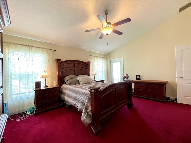 carpeted bedroom with vaulted ceiling, a textured ceiling, and ceiling fan