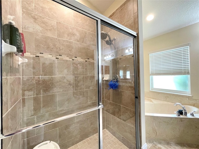 bathroom featuring a textured ceiling and independent shower and bath