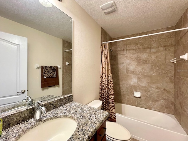 full bathroom with vanity, toilet, shower / tub combo with curtain, and a textured ceiling