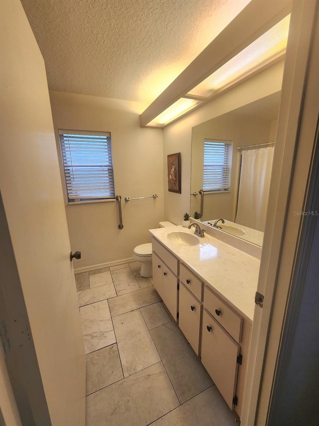 bathroom featuring a textured ceiling, vanity, and toilet