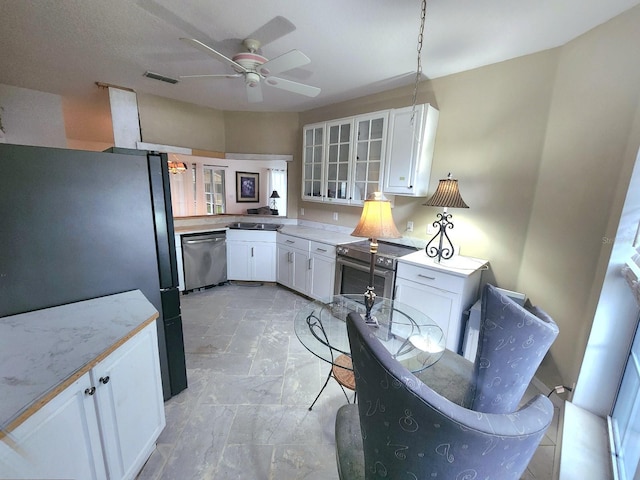 kitchen with appliances with stainless steel finishes, white cabinetry, and ceiling fan