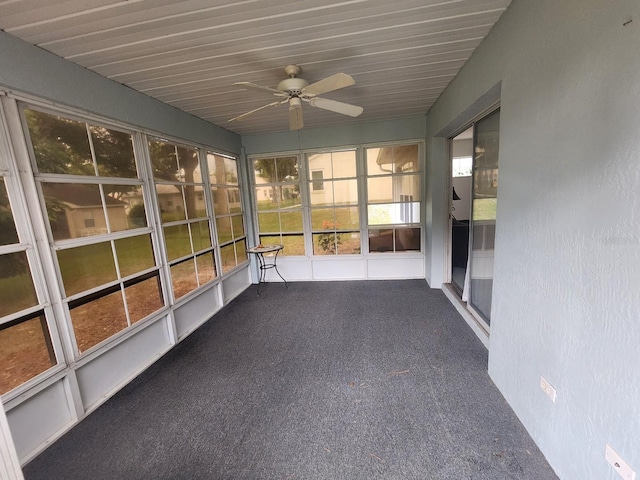 unfurnished sunroom with ceiling fan