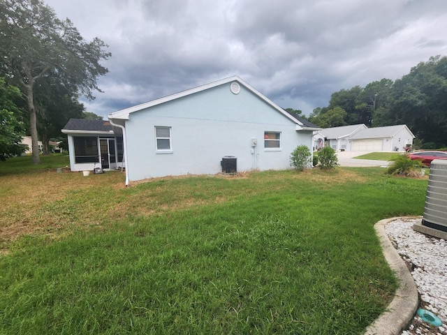 view of home's exterior featuring a lawn and central AC