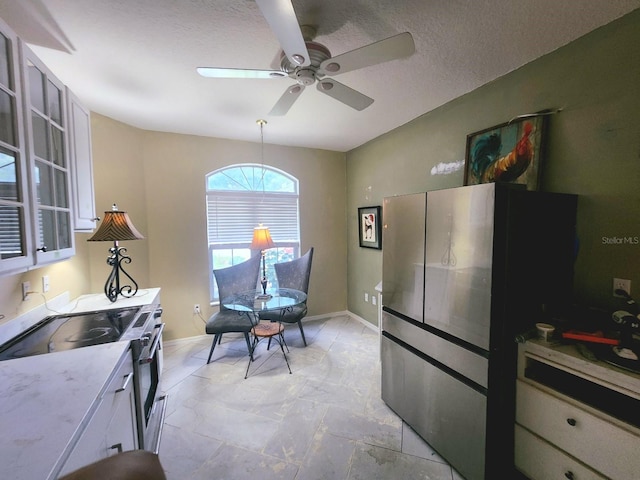 kitchen featuring white cabinetry, a textured ceiling, stainless steel electric stove, and ceiling fan