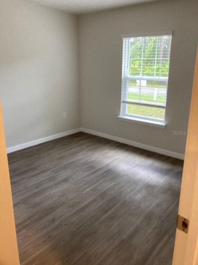 spare room with dark hardwood / wood-style floors