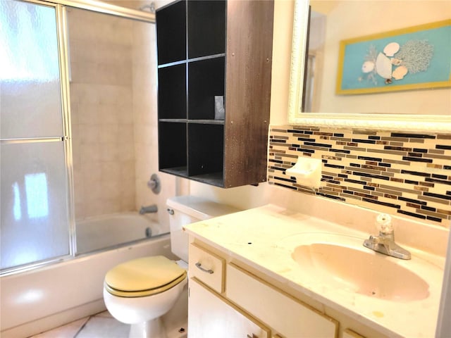 full bathroom with tile walls, vanity, combined bath / shower with glass door, and toilet