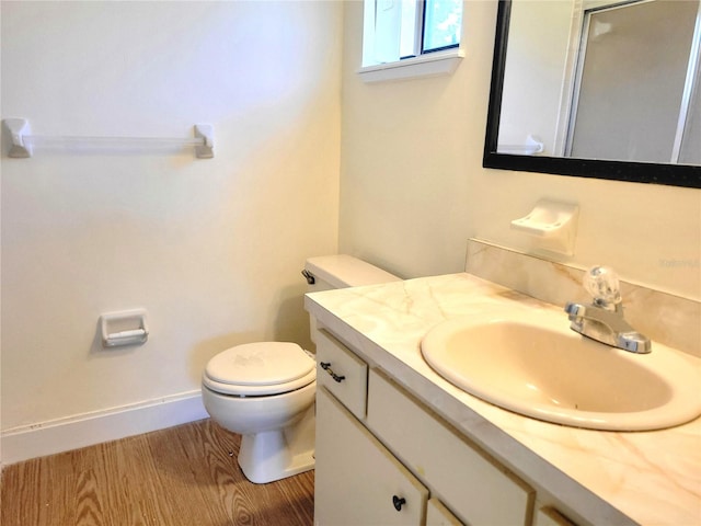 bathroom featuring vanity, wood-type flooring, and toilet