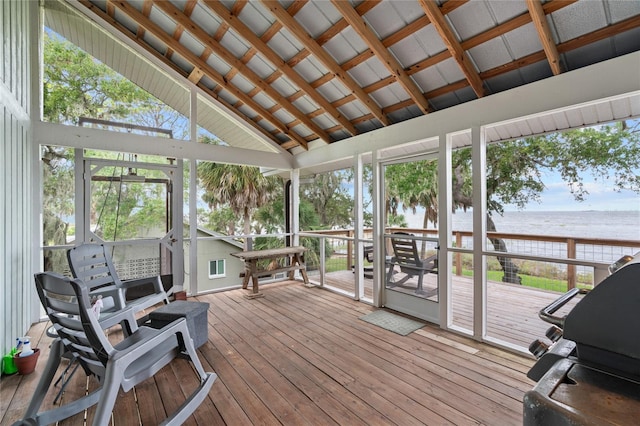 sunroom / solarium with vaulted ceiling, a healthy amount of sunlight, and a water view