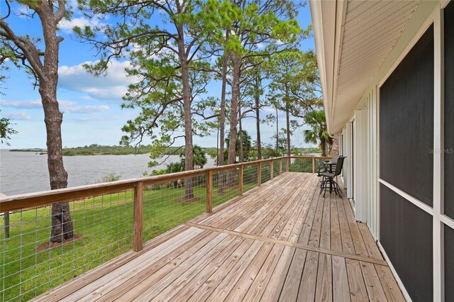 wooden terrace featuring a lawn and a water view