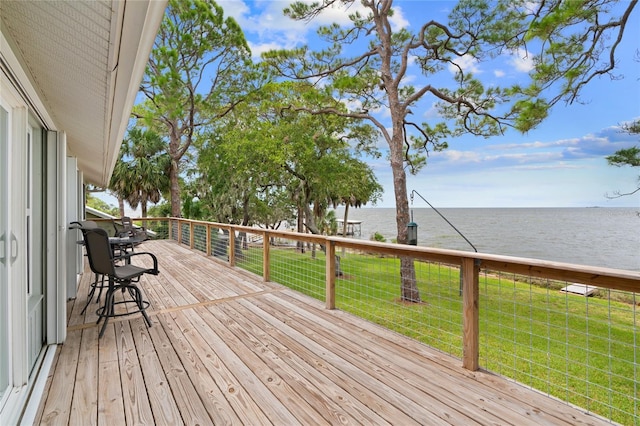 wooden deck with a yard and a water view