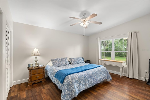 bedroom with vaulted ceiling, baseboards, and wood finished floors