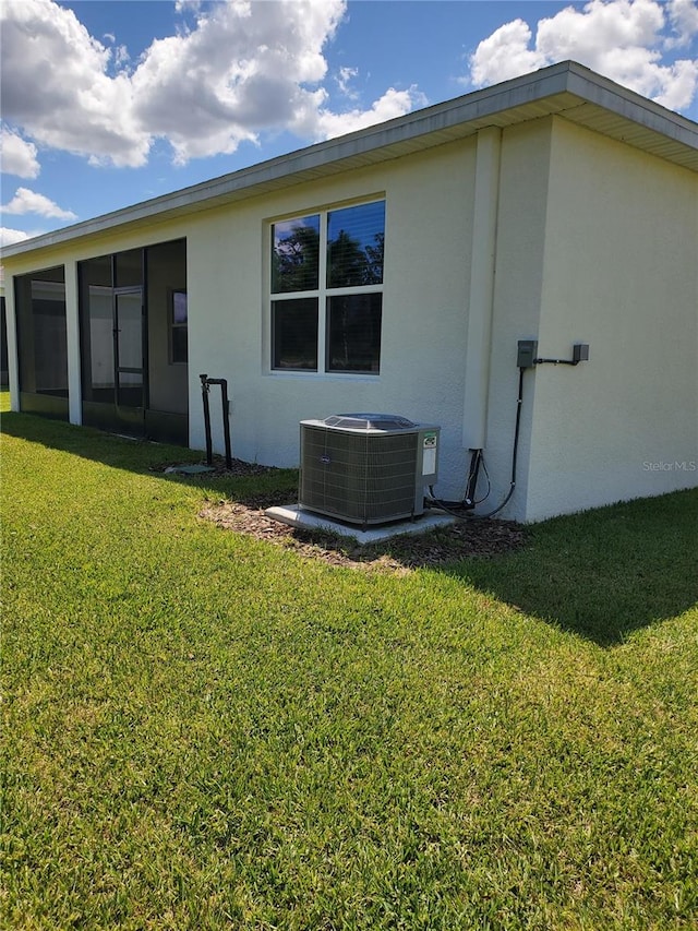 back of house featuring a lawn and central AC