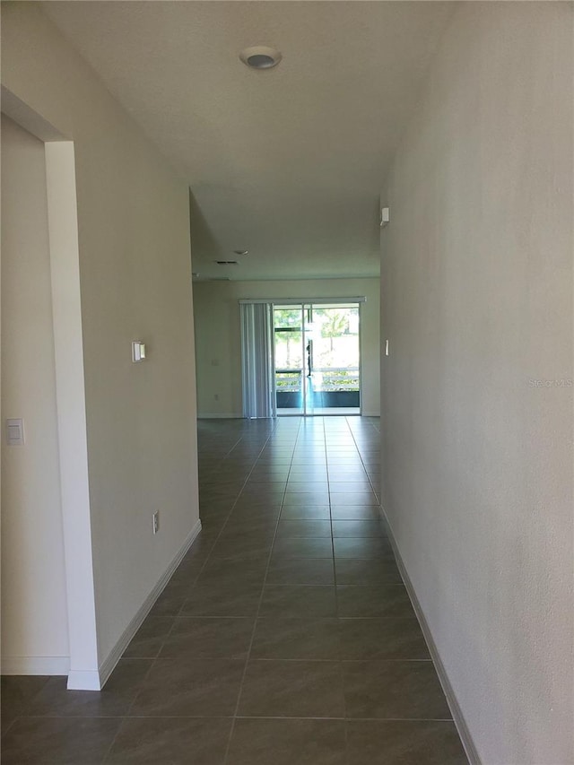 corridor featuring dark tile patterned floors